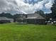 Expansive backyard featuring a screened-in porch and lush green lawn at 512 Ollas Walk, Mcdonough, GA 30252