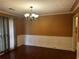 Elegant dining room with dark hardwood floors, wainscoting, and a modern chandelier at 512 Ollas Walk, Mcdonough, GA 30252
