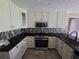 Modern kitchen with stainless steel appliances, granite countertops, and white cabinetry at 512 Ollas Walk, Mcdonough, GA 30252