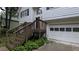 Charming two-story home with white siding, a one-car garage, and a welcoming wooden staircase leading to the entrance at 5710 Cardigan Trce, Sugar Hill, GA 30518