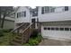 Charming two-story home with white siding, a one-car garage, and a welcoming wooden staircase leading to the entrance at 5710 Cardigan Trce, Sugar Hill, GA 30518