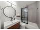 Modern bathroom with a sleek vanity, round mirror, and walk-in shower at 5968 Reddington Way, Sandy Springs, GA 30328