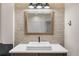 Modern bathroom vanity with a square vessel sink, wooden frame mirror, and stylish lighting fixtures at 5968 Reddington Way, Sandy Springs, GA 30328