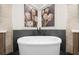 Relaxing bathroom features a sleek soaking tub with modern fixtures and decorative floral artwork at 5968 Reddington Way, Sandy Springs, GA 30328