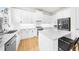 Kitchen features an island with seating, modern white cabinets, and stainless steel appliances at 5968 Reddington Way, Sandy Springs, GA 30328