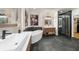 Luxurious main bathroom featuring dual sinks, a soaking tub, a glass enclosed shower, and stylish brick accents at 5968 Reddington Way, Sandy Springs, GA 30328