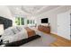 This main bedroom has hardwood floors, a seating area, and a large television for relaxation and entertainment at 5968 Reddington Way, Sandy Springs, GA 30328