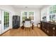 Stylish office with ample natural light, sleek black refrigerator and hardwood floors perfect for a home workspace at 5968 Reddington Way, Sandy Springs, GA 30328