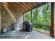 Covered patio with a grill, storage table, and views of the lush backyard at 5968 Reddington Way, Sandy Springs, GA 30328
