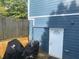 Backyard view with a blue house, wooden fence, and a covered motorcycle at 6701 Knollwood Cir, Douglasville, GA 30135
