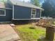 View of a backyard with a wooden deck, dark siding, and a wooded area at 6701 Knollwood Cir, Douglasville, GA 30135