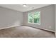 Bedroom with neutral walls and carpet flooring, large window with green outdoor view at 1707 Taylor Ave, Atlanta, GA 30344