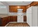 Well-lit kitchen features wood cabinets, modern white appliances, and wood-look flooring at 1707 Taylor Ave, Atlanta, GA 30344