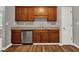 A kitchen with wooden cabinets, stainless steel dishwasher, and wood floors at 1707 Taylor Ave, Atlanta, GA 30344