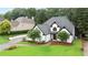 White house with dark trim surrounded by lush greenery, a well-kept lawn, and a winding driveway at 2714 Twin Leaf Trl, Marietta, GA 30062