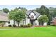 Charming home with well-manicured lawn, mature trees, and contrasting black and white trim details at 2714 Twin Leaf Trl, Marietta, GA 30062