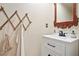Charming powder room with a decorative mirror, single vanity, and a rustic coat rack at 2714 Twin Leaf Trl, Marietta, GA 30062