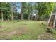 Sprawling backyard with mature trees, lush green grass, and access to a wooden deck at 3500 Stillwood Dr, Snellville, GA 30039