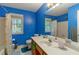 Bright blue bathroom features a large mirror, double windows, and a shower with curtain at 3500 Stillwood Dr, Snellville, GA 30039