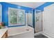 Bathroom featuring soaking tub, glass enclosed shower, and neutral color palette at 3500 Stillwood Dr, Snellville, GA 30039