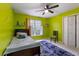 Bedroom features a green accent wall, ceiling fan, and a window with natural light at 3500 Stillwood Dr, Snellville, GA 30039