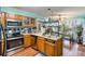 Efficient kitchen with wooden cabinets, modern appliances, and view to a bright, plant filled breakfast nook at 3500 Stillwood Dr, Snellville, GA 30039