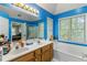 Main bathroom featuring double sinks, a soaking tub, and a glass-enclosed shower at 3500 Stillwood Dr, Snellville, GA 30039