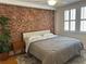 Cozy bedroom featuring a brick wall, hardwood floors, natural light, and a comfortable bed at 1078 Piedmont Ne Ave # 206, Atlanta, GA 30309