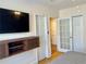 Well-lit bedroom with hard wood floors, closet, and contemporary floating entertainment console at 1078 Piedmont Ne Ave # 206, Atlanta, GA 30309