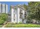 Charming white three-story home featuring private balconies, lush landscaping and manicured lawn at 1078 Piedmont Ne Ave # 206, Atlanta, GA 30309