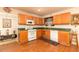 Well-lit kitchen with wood cabinets, white appliances, and green countertops with an adjacent dining area at 1382 Koble Mill Ln, Riverdale, GA 30296