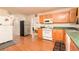 Functional kitchen with wood cabinets, white appliances, green countertops, and spacious layout at 1382 Koble Mill Ln, Riverdale, GA 30296