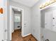 A bathroom with a large mirror, white door, light fixture, and a view of a room with a window at 5267 Sheppard Ln, Stone Mountain, GA 30083