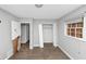 This bedroom is worn, with laminate flooring and a window with blinds and a closet at 5267 Sheppard Ln, Stone Mountain, GA 30083