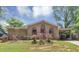 Charming brick home featuring a covered front porch, complemented by a lush green lawn and mature trees at 5267 Sheppard Ln, Stone Mountain, GA 30083