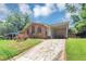 Charming brick home featuring a covered front porch and long driveway, complemented by a lush green lawn and mature trees at 5267 Sheppard Ln, Stone Mountain, GA 30083
