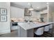 Modern kitchen features white cabinets, quartz counters, stainless appliances, and gray island with bar seating at 912 Sunny Meadows Ln, Marietta, GA 30062