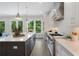 Open kitchen features white cabinets, stainless appliances, quartz counters, gray island, and view to deck at 912 Sunny Meadows Ln, Marietta, GA 30062