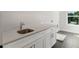 Bright laundry room featuring white cabinetry, sleek countertop, and convenient sink for added functionality at 912 Sunny Meadows Ln, Marietta, GA 30062