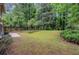 Expansive backyard featuring a lush lawn, mature trees, a storage shed, and a concrete patio, offering a private outdoor space at 112 Valley Rd, Stockbridge, GA 30281