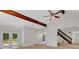 Inviting living room featuring wood beams, ceiling fan, hardwood floors, and ample natural light at 112 Valley Rd, Stockbridge, GA 30281