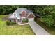 Aerial view of a two-story brick home with lush trees, a long driveway, and a well-manicured lawn at 1245 Grace Hadaway Ln, Lawrenceville, GA 30043