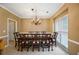 Formal dining room featuring a large table with seating for ten, chandelier, and natural light at 1245 Grace Hadaway Ln, Lawrenceville, GA 30043
