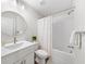 This bathroom has a tiled shower over tub, a white vanity, and a round mirror at 1247 Zucchini Se Cir, Atlanta, GA 30315