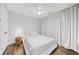 This bedroom features wood floors, a ceiling fan, and bright natural lighting with white walls and curtains at 1247 Zucchini Se Cir, Atlanta, GA 30315
