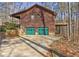 Rustic home exterior with green garage doors and second story deck surrounded by trees at 3452 Monica Lane Southwest Sw Ln, Conyers, GA 30094