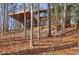 Exterior view of a rustic home with a deck supported by beams amongst the trees at 3452 Monica Lane Southwest Sw Ln, Conyers, GA 30094