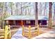 Charming wood cabin with a covered front porch surrounded by a tranquil wooded landscape at 3452 Monica Lane Southwest Sw Ln, Conyers, GA 30094