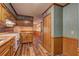 Eat in kitchen featuring bright checkered wallpaper, butcher block countertops, wood floors and rustic cabinetry at 3452 Monica Lane Southwest Sw Ln, Conyers, GA 30094