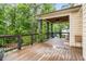 Back porch with dark rails and columns, wooden floors, a ceiling fan, and views of lush greenery at 374 Beaumont Farms Dr, Sharpsburg, GA 30277